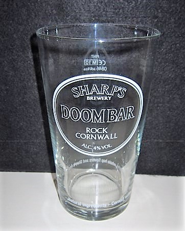 beer glass from the Sharp's brewery in England with the inscription 'Sharp's Brewery Doombar Rock Cornwall Alc 4% VOL Cornish Water, English Malted Barley, Whole Hop Flowers And Sharp's unique Yeast '