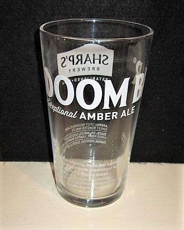 beer glass from the Sharp's brewery in England with the inscription 'Doombar Exceptional Amber Ale, Named After The Informous Doombar Sandbank On The Cornwall's Riged North Coast Where the River Camel Meets The Atlantic Ocean.'