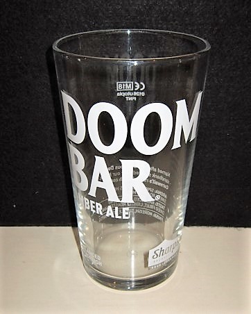 beer glass from the Sharp's brewery in England with the inscription 'Doombar Amber Ale, Balanced&Moreish Sharp's Brewery Rock Cornwall'