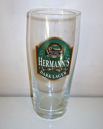 beer glass from the Vancouver Island brewery in Canada with the inscription 'Hermann's 100% Natural, Vancouver Island Brewery. Made With Barley,Water,Hops, And Yeast Specialty Brewed In Victoria BC, Dark Lager'