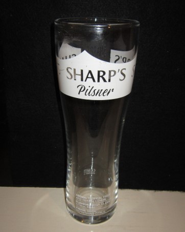 beer glass from the Sharp's brewery in England with the inscription 'Sharp's Pilsner, Aroma, Tropical Fruit And Herbal Lemon. Flavour, Crisp Clean Citrus Fruit. Finish, Brisk Refreshing Citrus'