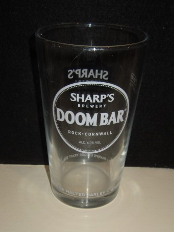 beer glass from the Sharp's brewery in England with the inscription 'Sharp's Brewery, Doombar Rock Cornwall Alc 4.05 Vol. English Malted Barley-Whole Hop Flowers-Sharps Unique Yeast-Cornish Water'